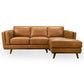 The Ashcroft Furniture Chase MCM Tan Leather Chaise Sofa Sectional 92 features three seat cushions, a right-side chaise lounge, angled armrests, and wooden legs in a mid-century modern style, all set against a white background.