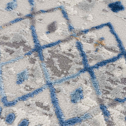 Close-up of a Moroccan styled woven area rug in blue and beige tones, featuring intricate geometric patterns.