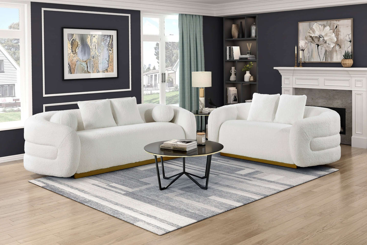White sherpa loveseat paired with a round black coffee table in a stylish living room setting.
