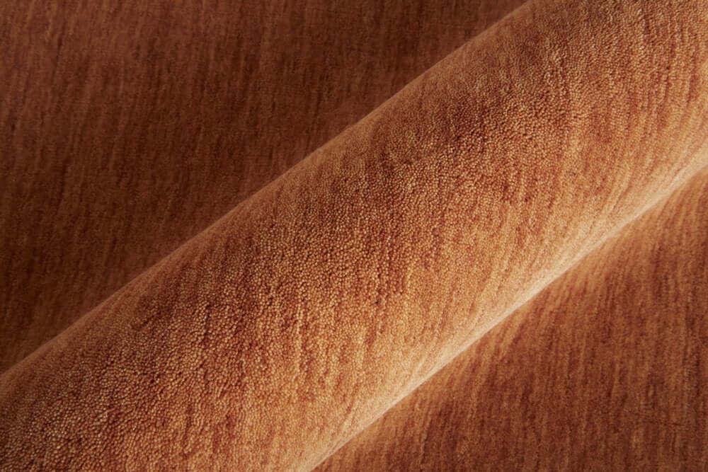 Close-up of texture of Orange Wool Hand Woven Area Rug | 9' x 13', showcasing warmth and durability.