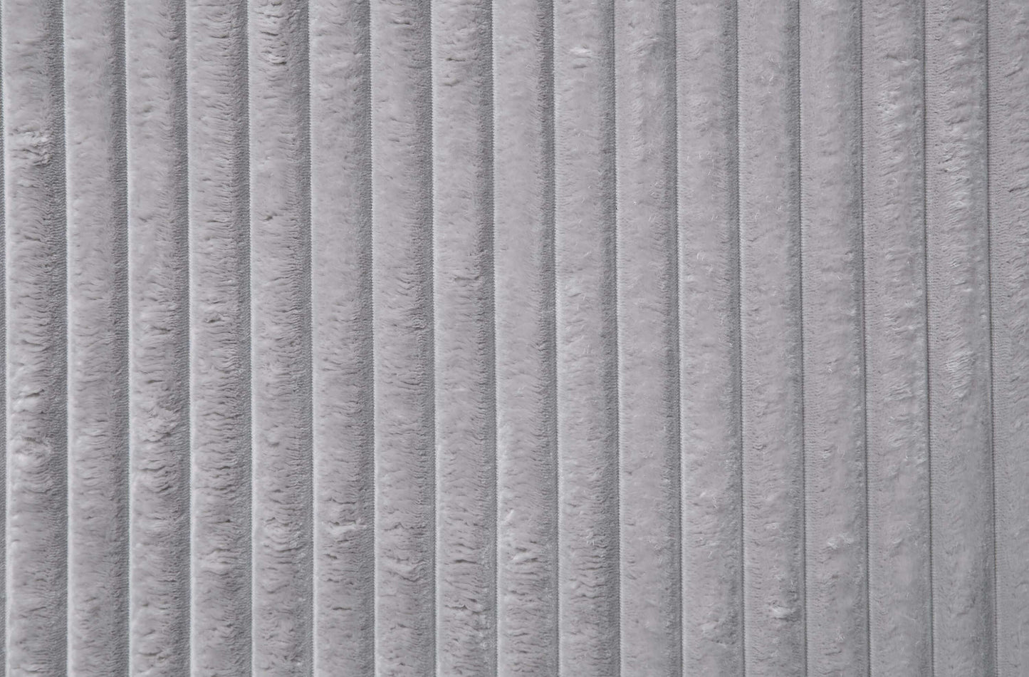 Close-up of gray corduroy fabric texture showcasing vertical ridges and plush softness.