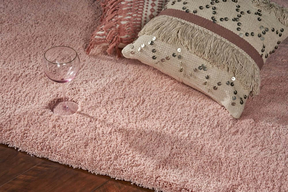 Pink Shag Hand Woven Area Rug | 9' x 13' with a decorative pillow and glass, showcasing soft texture and comfort.