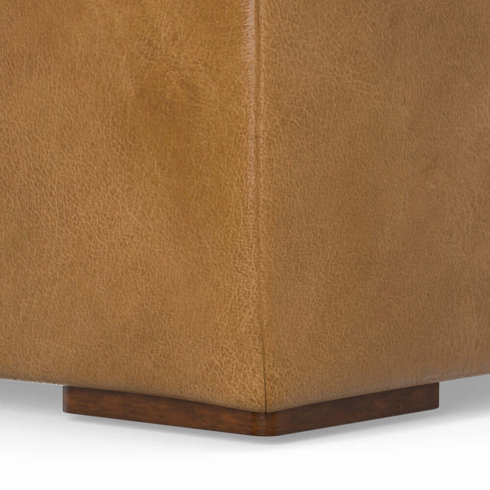 Close-up of Rex Genuine Leather Square Ottoman corner with wooden base, showcasing rich texture and luxury design.
