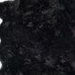 Close-up of soft black faux fur shag rug, showcasing plush texture and scalloped design ideal for modern decor.