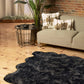 Scalloped faux fur shag rug in a modern living room setting, paired with decorative pillows and plants.