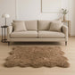 Soft scalloped faux fur shag rug in beige under a stylish modern sofa, enhancing cozy home decor.