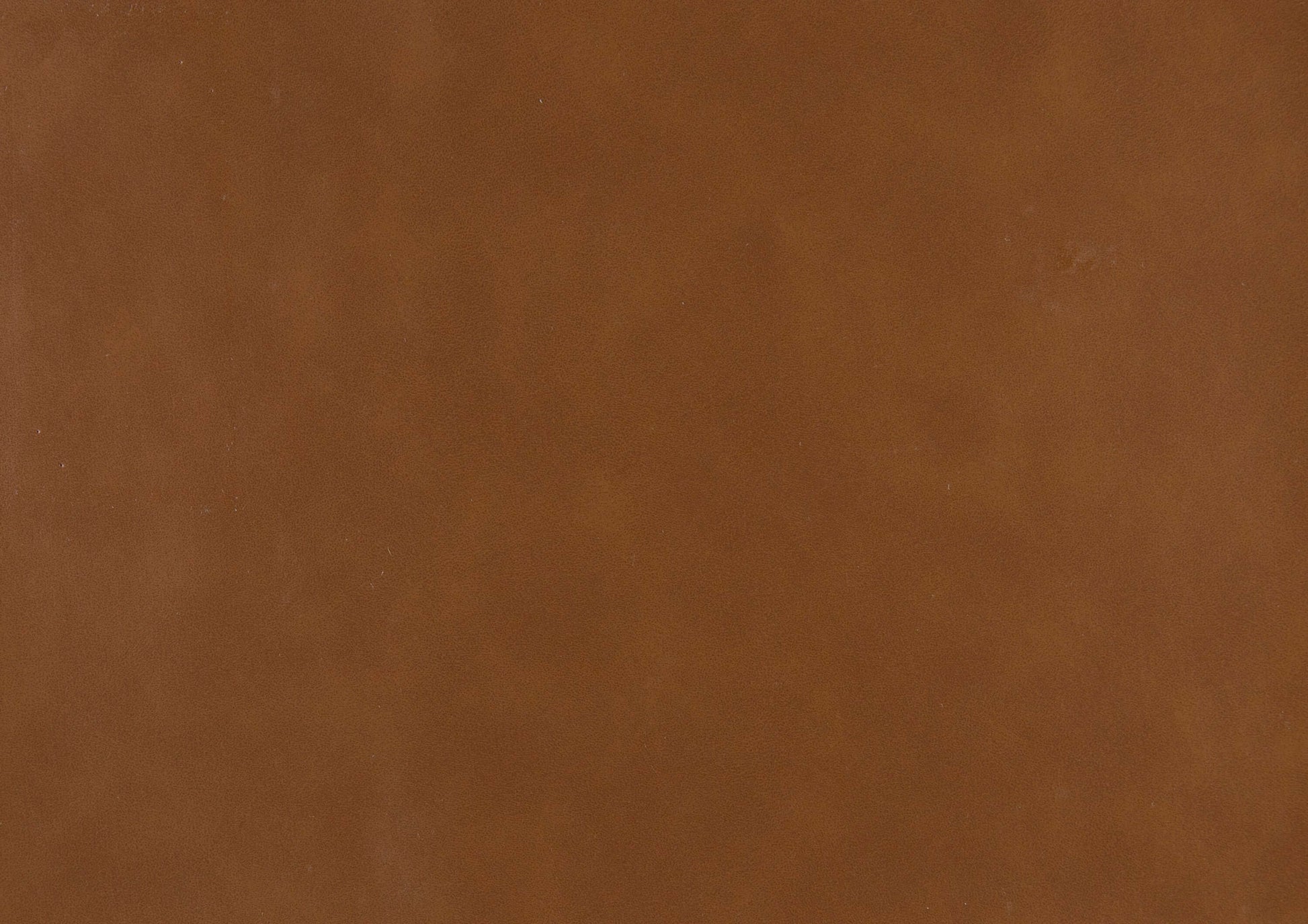 Close-up of faux leather material in warm brown, suitable for upholstery and modern furniture.