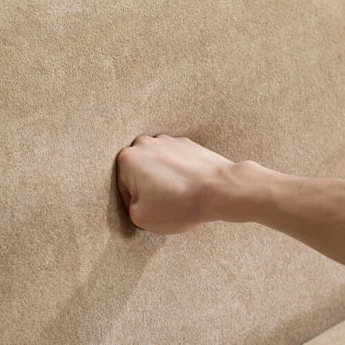 Hand pressing into the soft boucle fabric of the Tonson Boucle Sofa – 83” Curved Wave 3-Seater Sofa (3 Colors, Modern Sculptural Design)