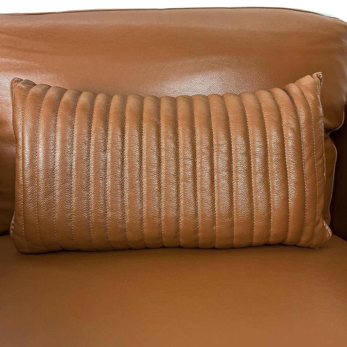 Tussio Saddle Tan Leather Chair – Italian Modern Accent Chair with Pillow featuring a textured brown pillow