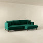 The Ashcroft Furniture Blake Velvet Upholstered L-Shape Chaise Sofa Sectional 107 features plush velvet upholstery, clean lines, and a reversible chaise, shown in a minimalist room with plain beige walls and floor.