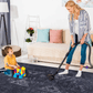 Mom vacuuming black washable rug while child plays with building blocks in a stylish living room.
